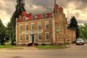 A brick building with red roof and green trim.