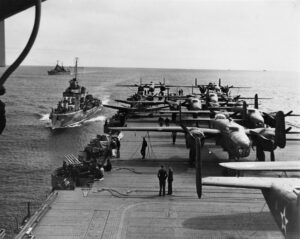 A group of planes on the deck of an aircraft carrier.